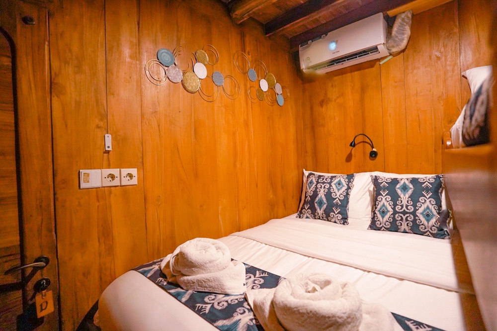 Double bed cabin with round decorative wall art and wood paneling