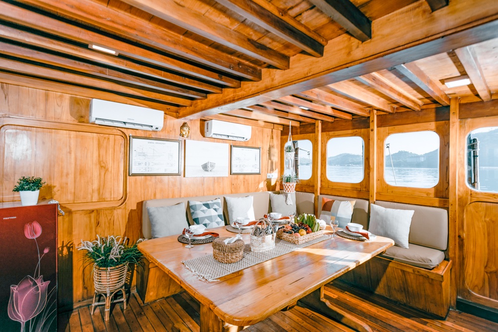 Adishree's wood-paneled indoor dining lounge with cushioned bench seating and ocean-view windows