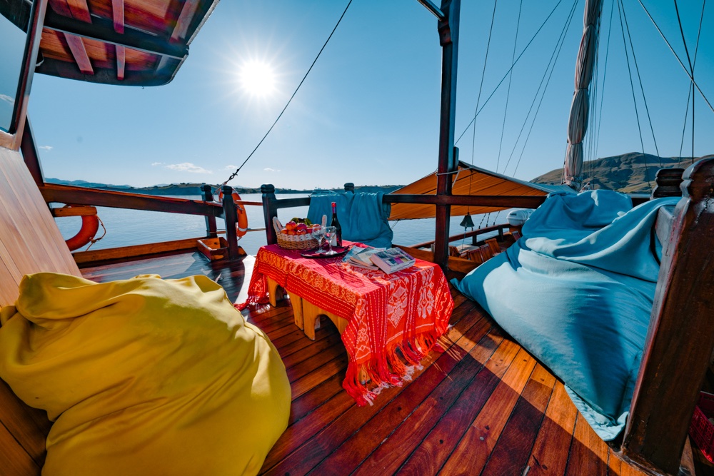 Yellow and blue beanbags around a red-clothed table on Adishree's sunlit deck