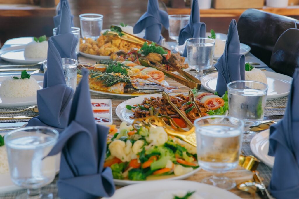 Grilled fish and vegetables served on Akassa Cruise's table with blue napkins
