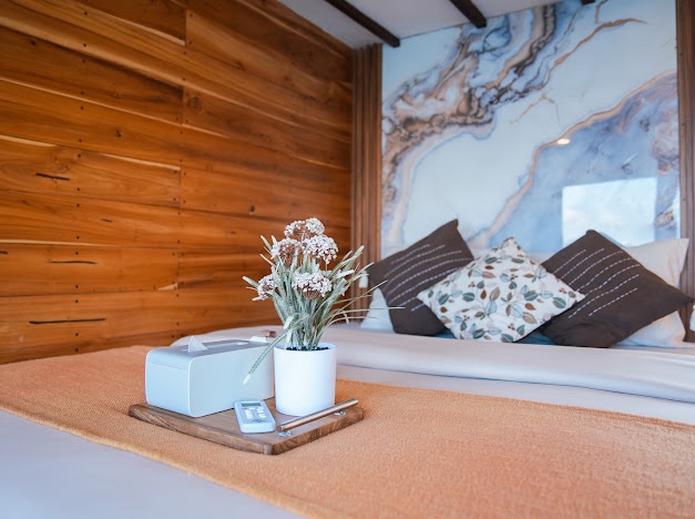 Small tray of amenities and a plant resting on a bed aboard Akassa Cruise