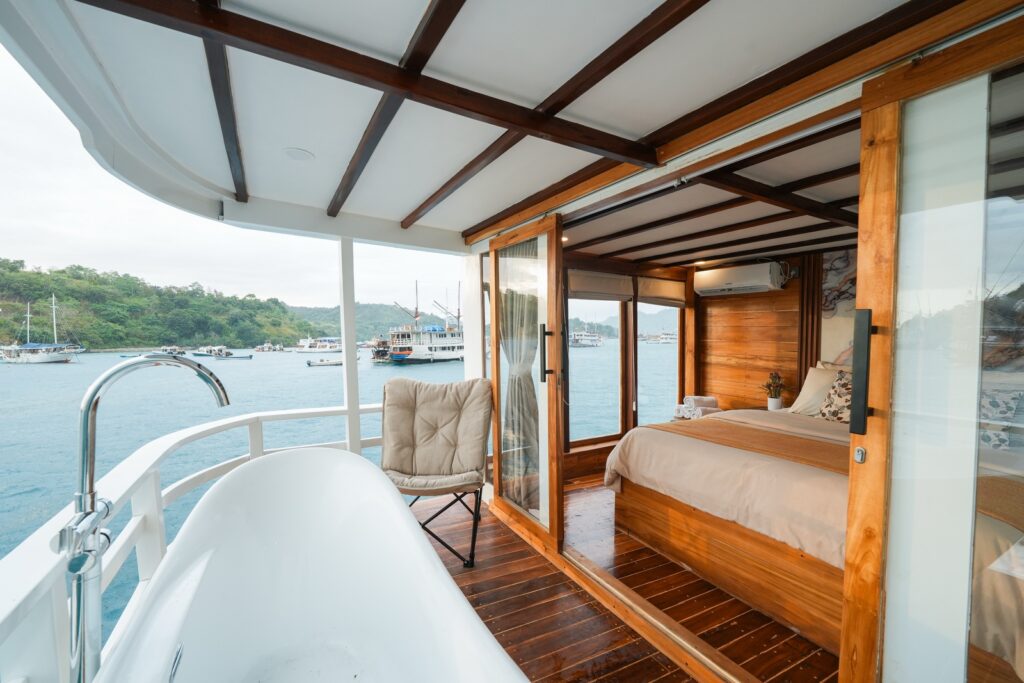 Akassa Cruise private balcony with a freestanding bathtub and lounge chair by the bedroom