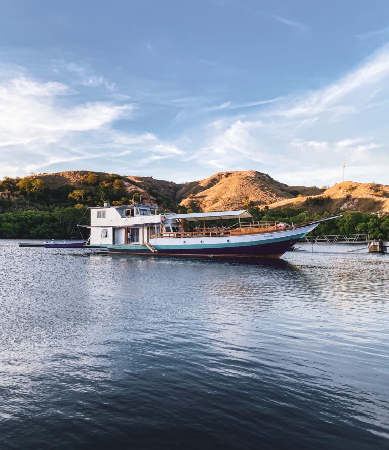 Amalfi komodo liveaboard anchored near golden hills at dusk
