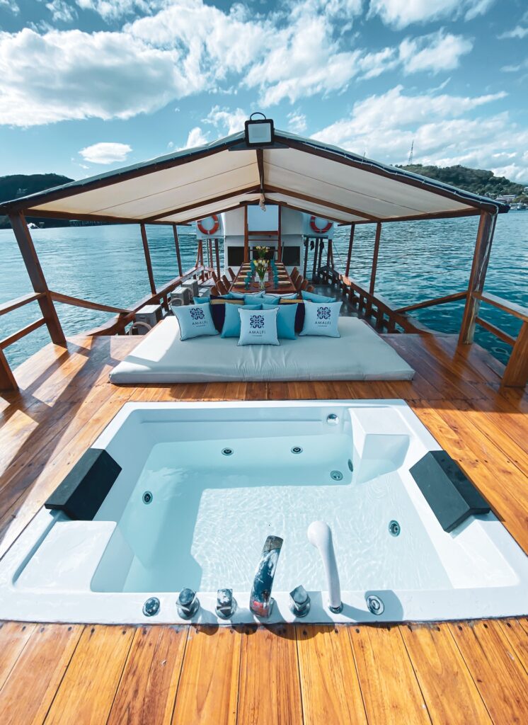 Rooftop jacuzzi with a shaded daybed lounge and harbor view in the background