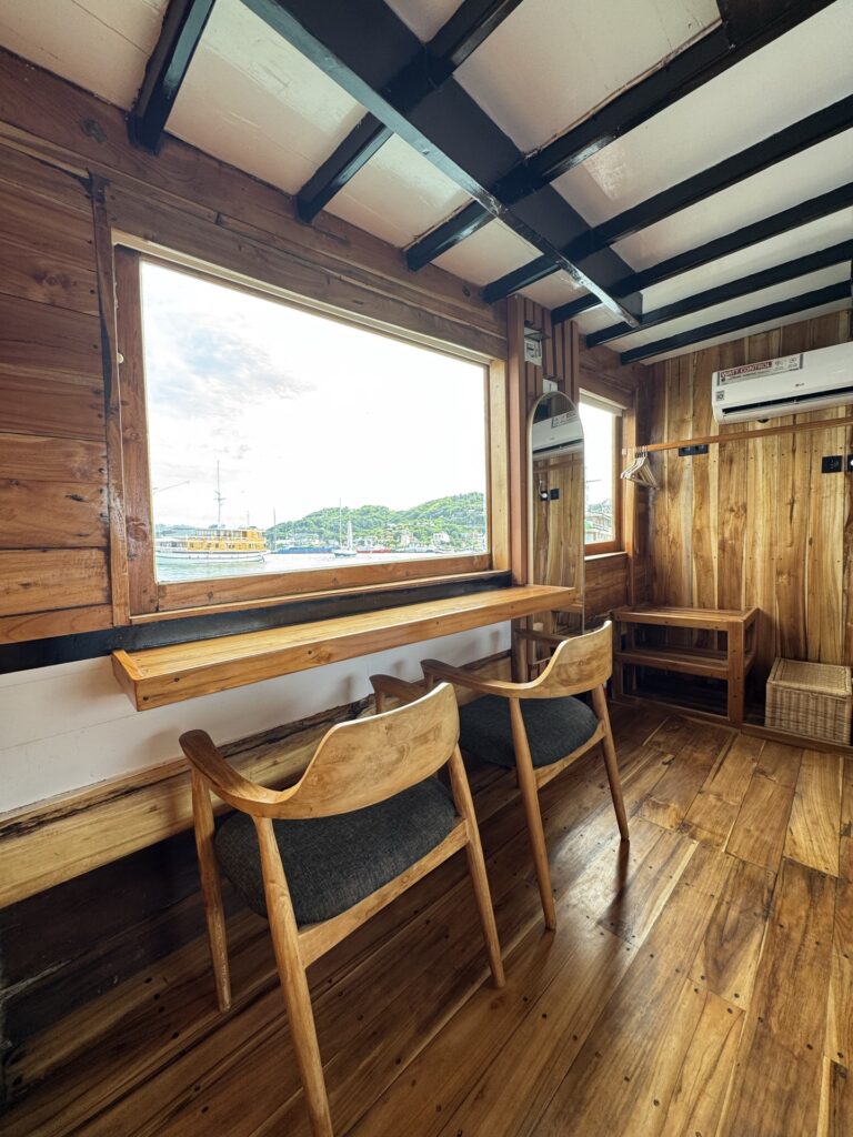 Andalucia cabin nook with two wooden armchairs by a harbor-view window