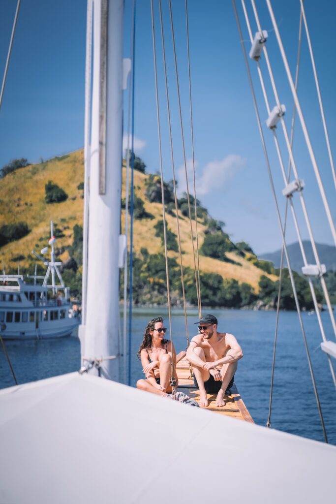 Couple sitting together on the bow with golden hills in the background