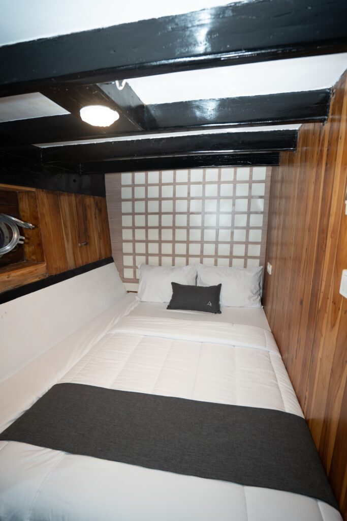 Andalucia cabin bed with a grey runner beneath a patterned headboard wall