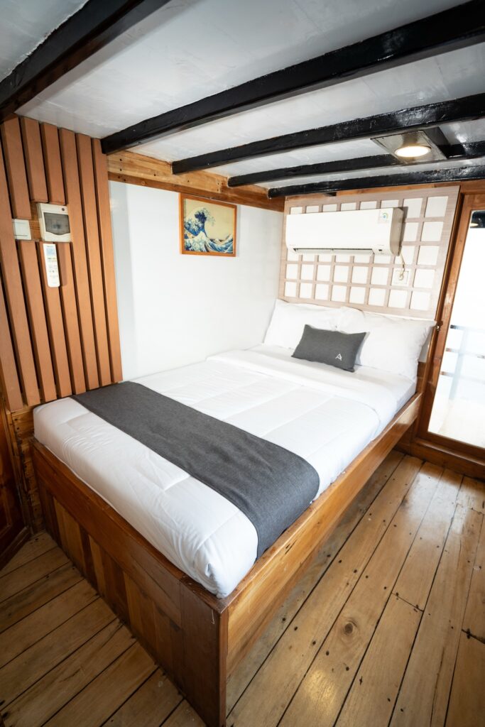 Andalucia cabin bed with a grey striped runner and wood-paneled walls