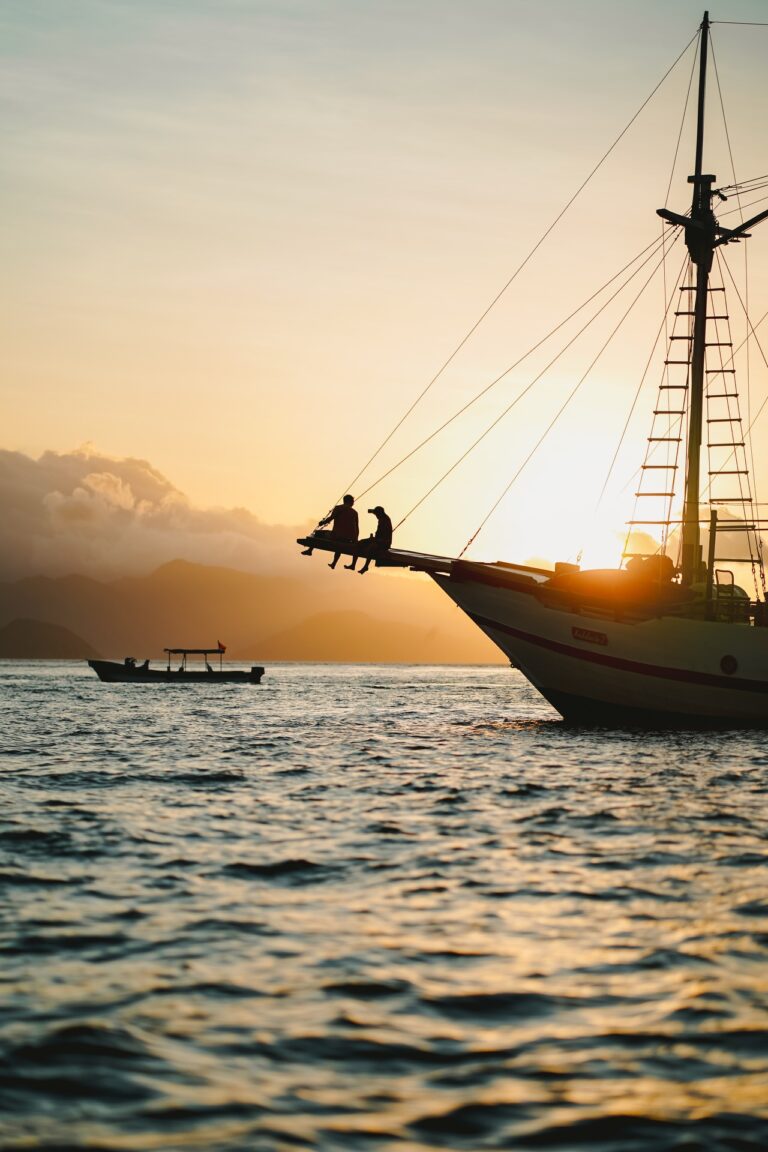 Andalucia's silhouette at sunset with guests seated on the bowsprit