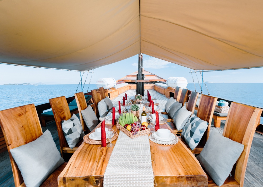 Deck lunch table under a canopy with a fruit centerpiece and red candles