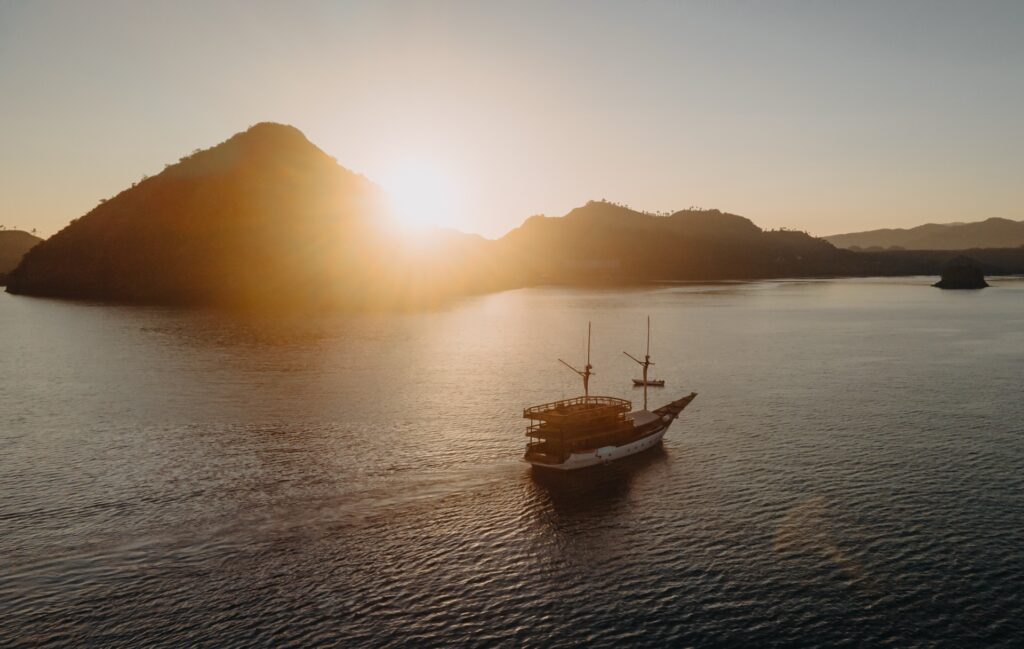 Andamari sailing between hills during a golden sunset