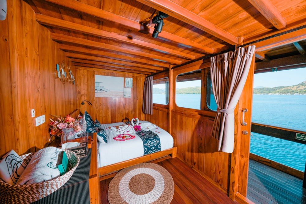 Andamari master bedroom with floral towel art and ocean-view windows