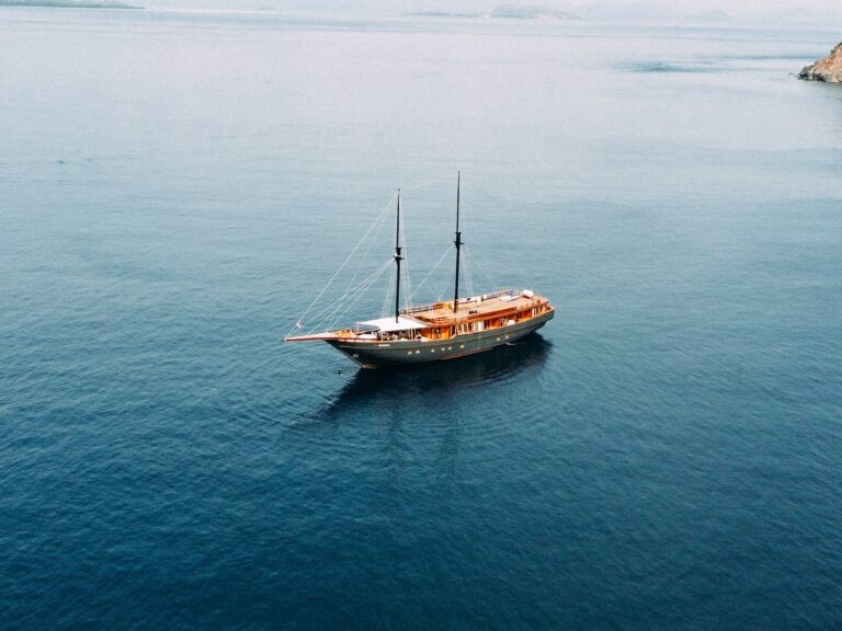 Aerial view of Angelica anchored on open blue water near a distant island