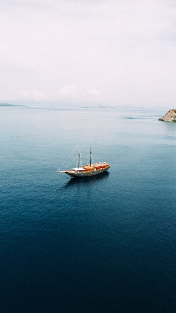 Aerial drone view of Angelica anchored alone on open blue water