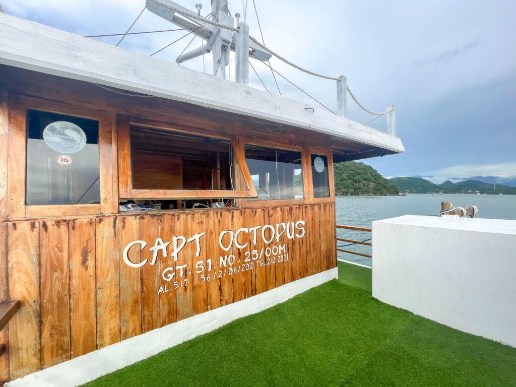 Capt Octopus nameplate painted on the wood exterior above the turf deck