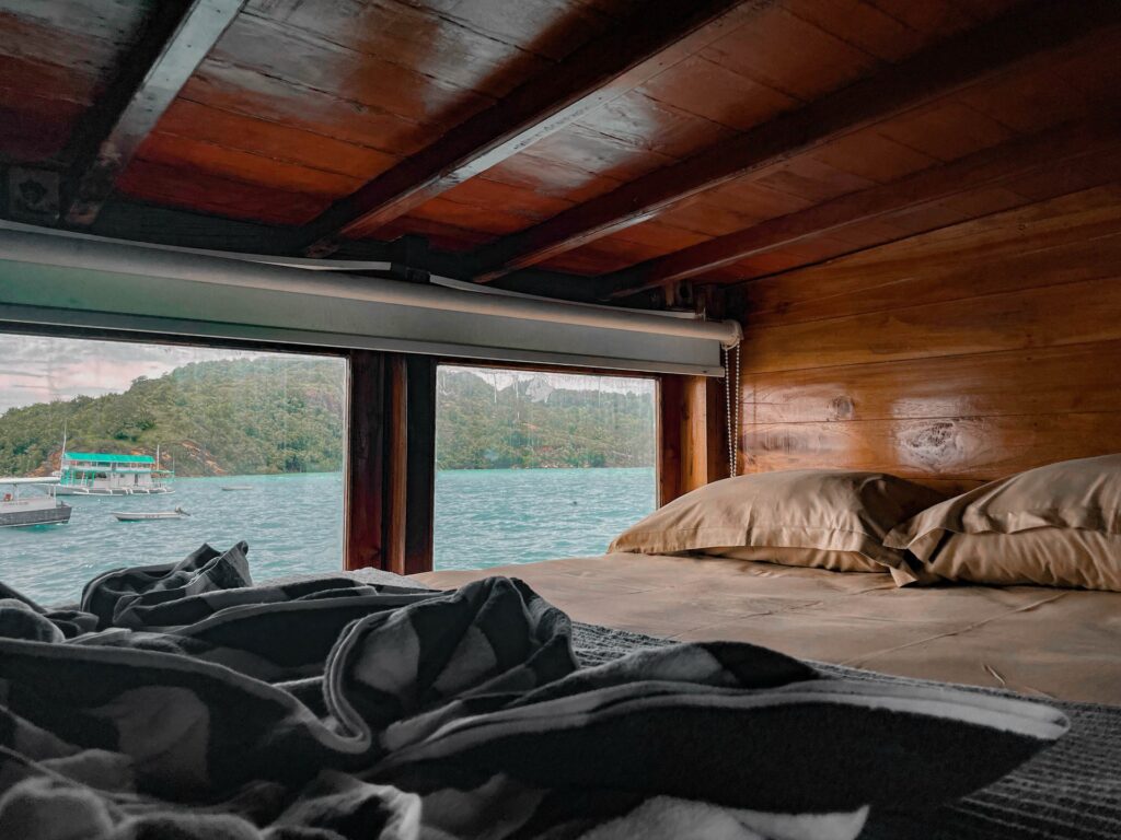 Family suite bed facing a wide window overlooking the harbor