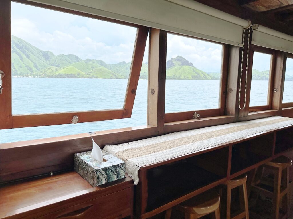 Lounge windows framing a mountain and ocean view above wooden shelving