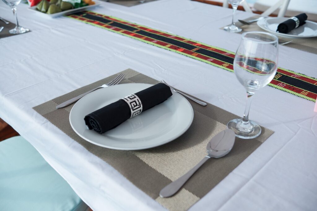 Table setting with a black napkin, white plate and glassware