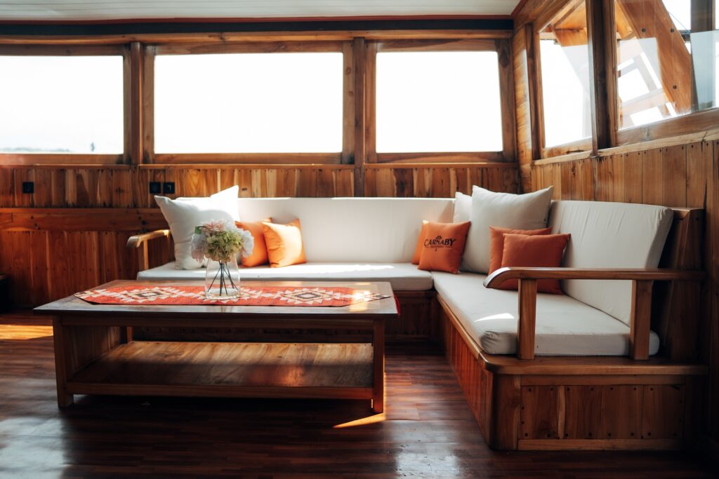 Salon seating with white cushions and orange throw pillows around a coffee table