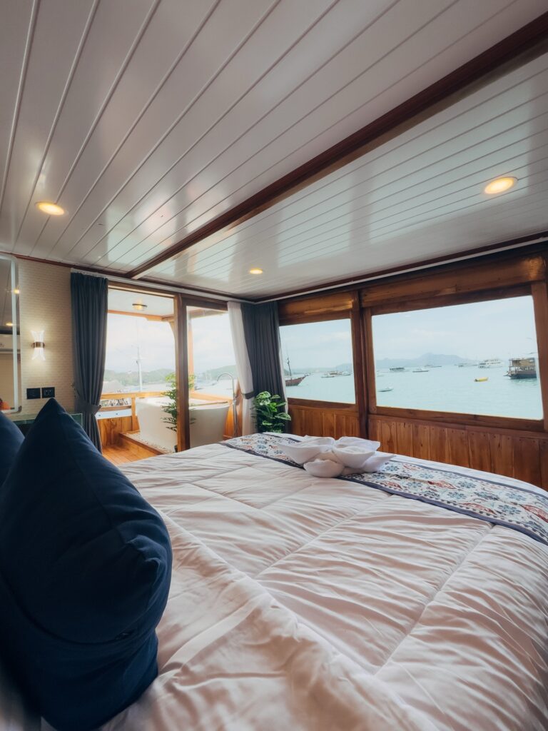 Carnaby II master suite bed beside wraparound windows overlooking the bay