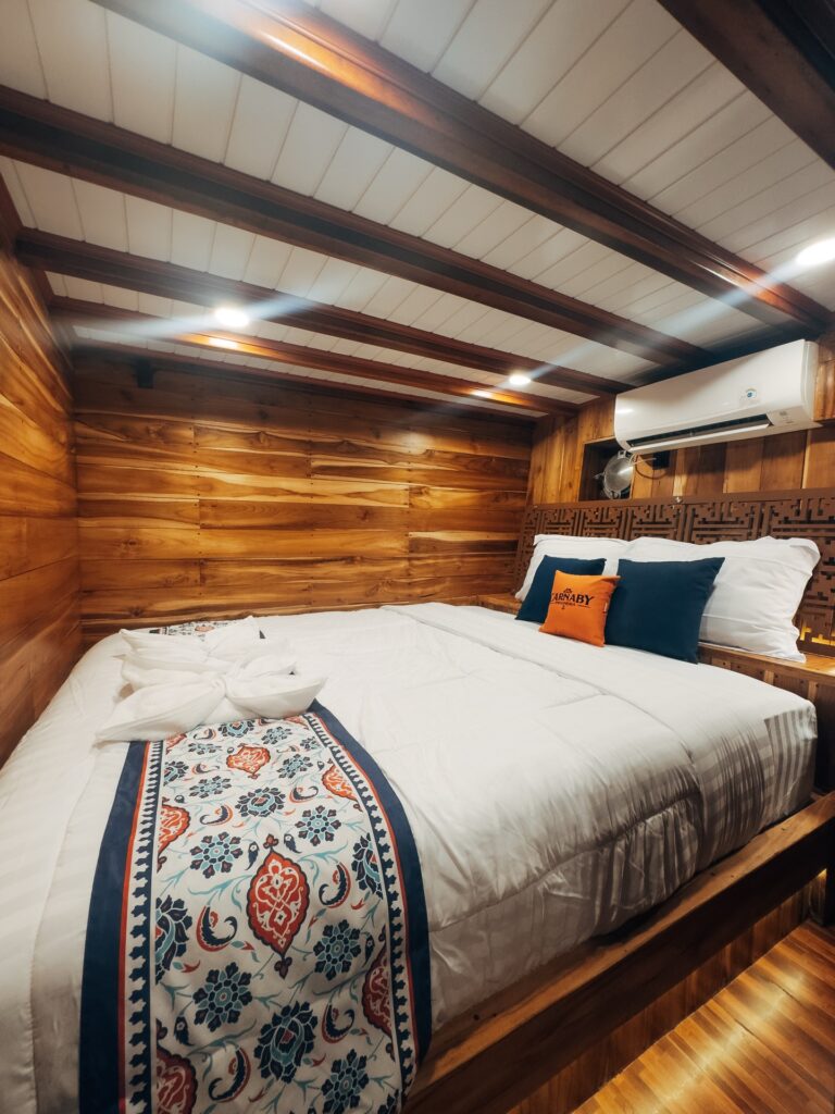 Superior cabin bed with a patterned throw set against wood panelled walls