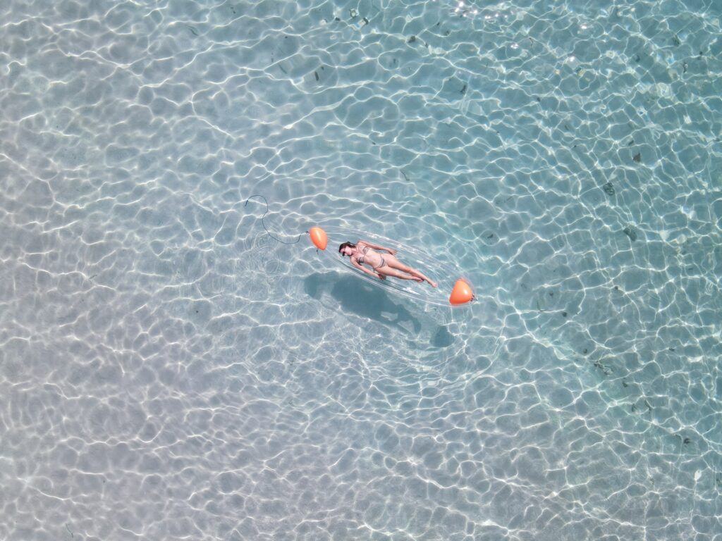 A guest floating on the surface of clear shallow water