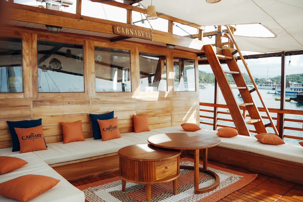 Outdoor lounge with branded pillows, orange cushions and a round coffee table