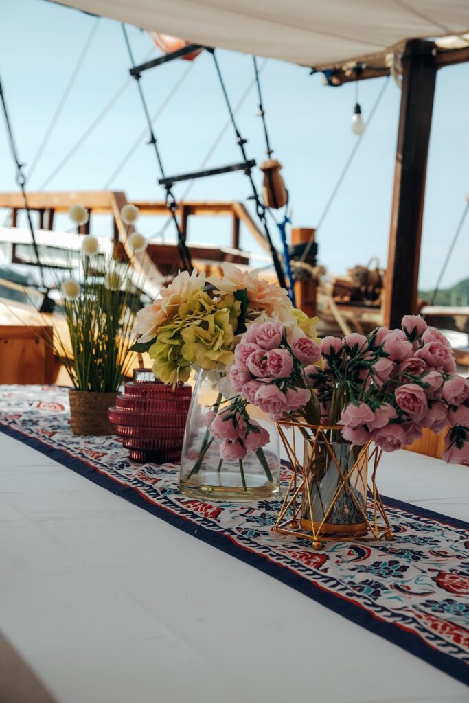 Fresh flowers in vases on a dining table with a patterned runner