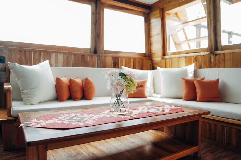 Indoor lounge with white cushioned bench seating and orange throw pillows
