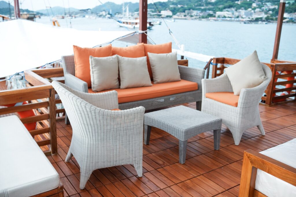 Carnaby I outdoor wicker lounge with orange cushions and a small table