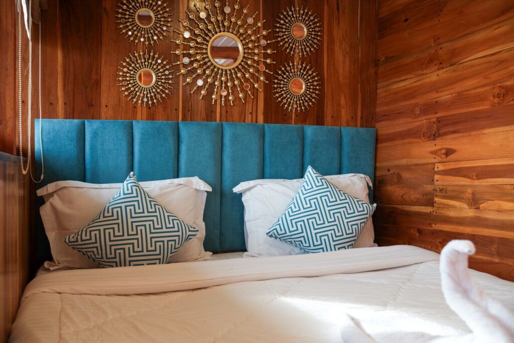 Deluxe cabin bed with a blue headboard and gold sunburst mirror decor