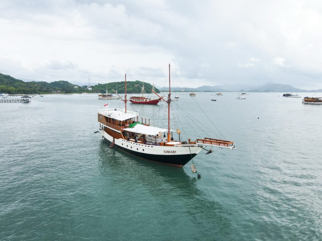 Carnaby I anchored with other boats and green hills in the background