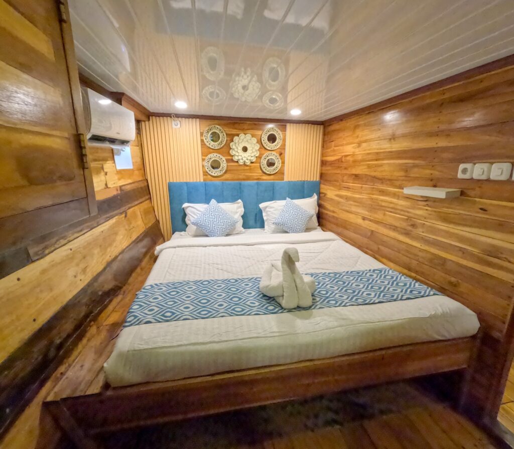 Carnaby I superior lower deck room with a teal headboard and wall clock