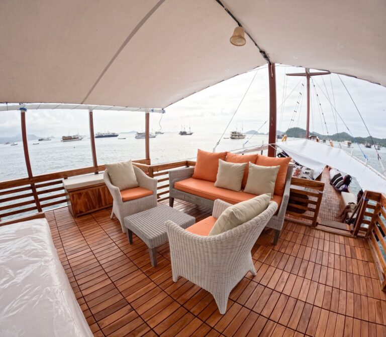 Carnaby I komodo liveaboard upper deck lounge with wicker chairs and orange cushions