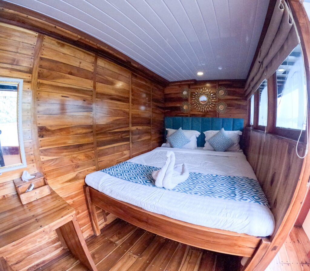Carnaby I deluxe bedroom bed with a teal headboard and wood-paneled walls