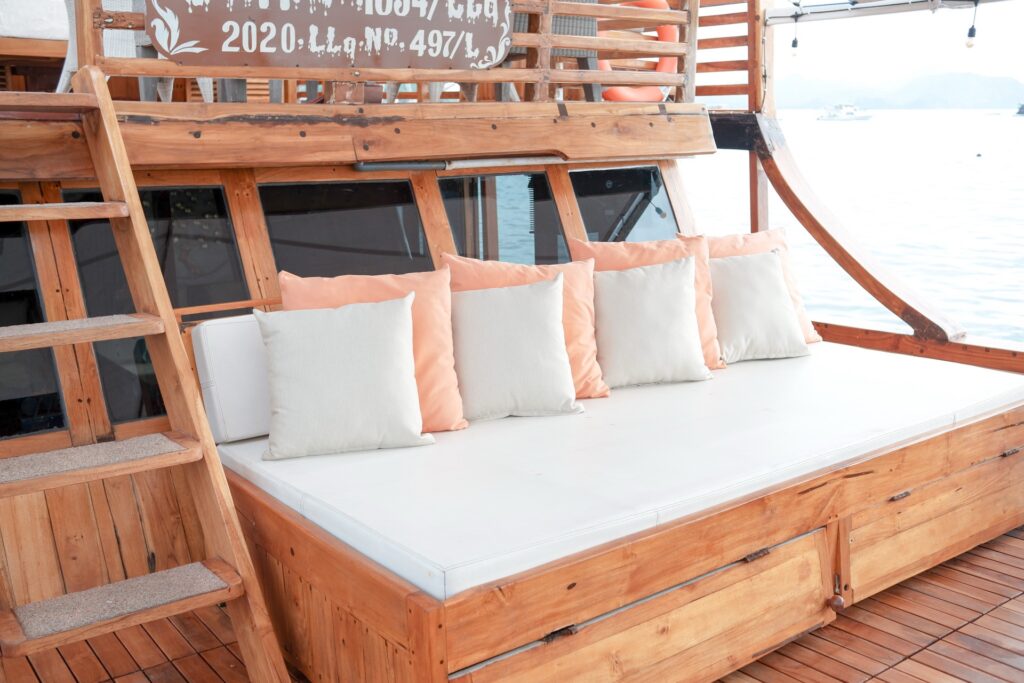 Shaded wooden daybed with cream and peach cushions on the deck
