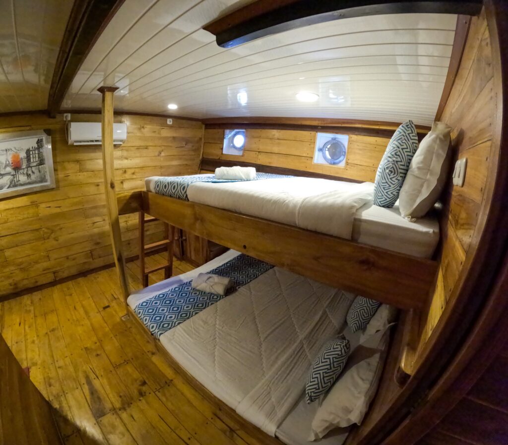 Family room with bunk beds, wood paneling and small portholes