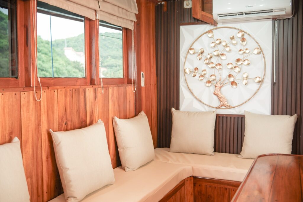 Indoor lounge with cream cushioned seating and a decorative tree wall art