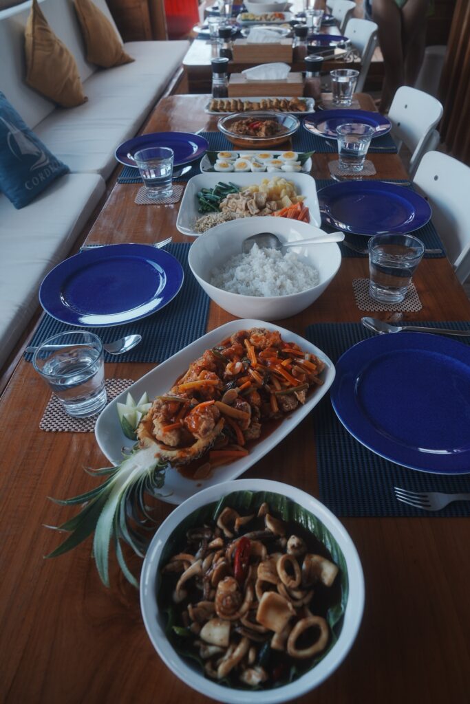 Indonesian lunch buffet spread with rice, seafood and vegetables on a wooden table