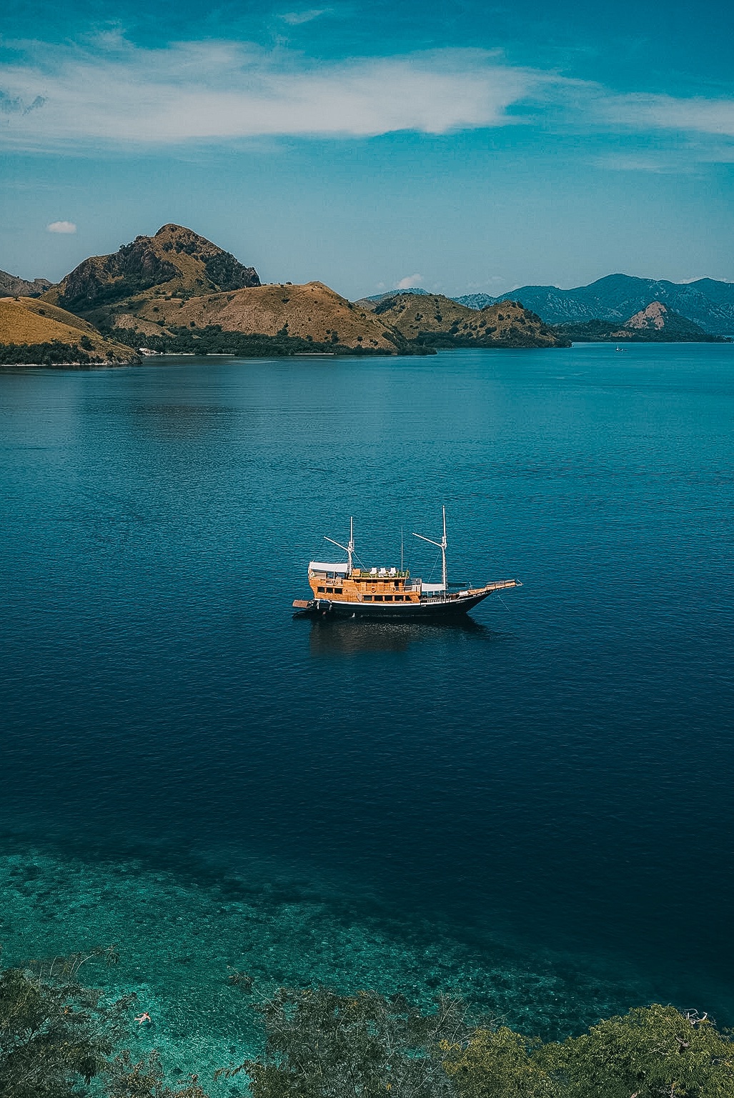 Aerial view of the Cordelia boat anchored in a bay near Kalong Island