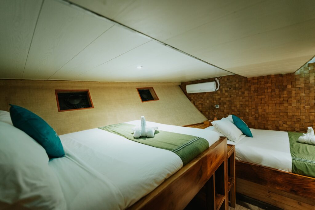 Triple cabin with a double bed and adjacent single bed in a wood interior