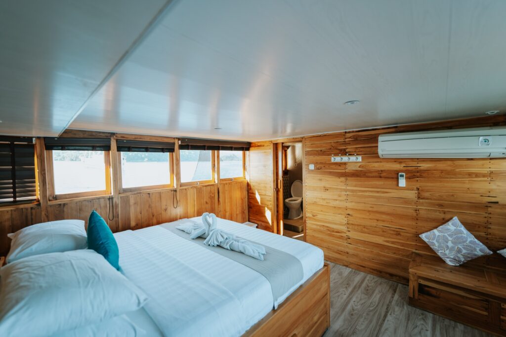 Cordelia phinisi master bedroom with wraparound windows and an air conditioning unit