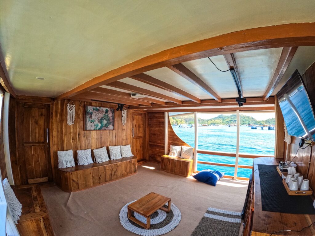 Lounge area on the Dinara with wooden bench seating and a low table