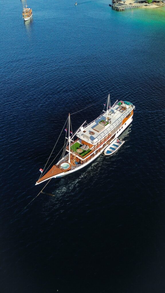 Aerial view of the Dinara anchored in deep blue water near Kanawa Island