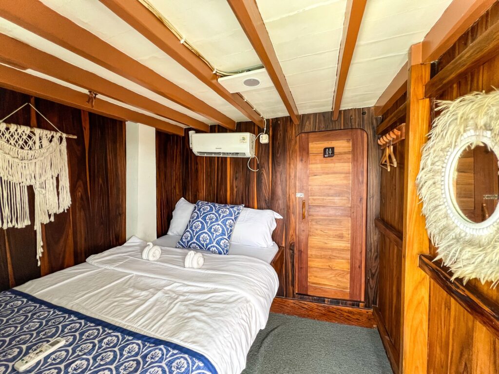Deluxe bedroom with blue patterned pillows, a macrame hanging and a feathered mirror