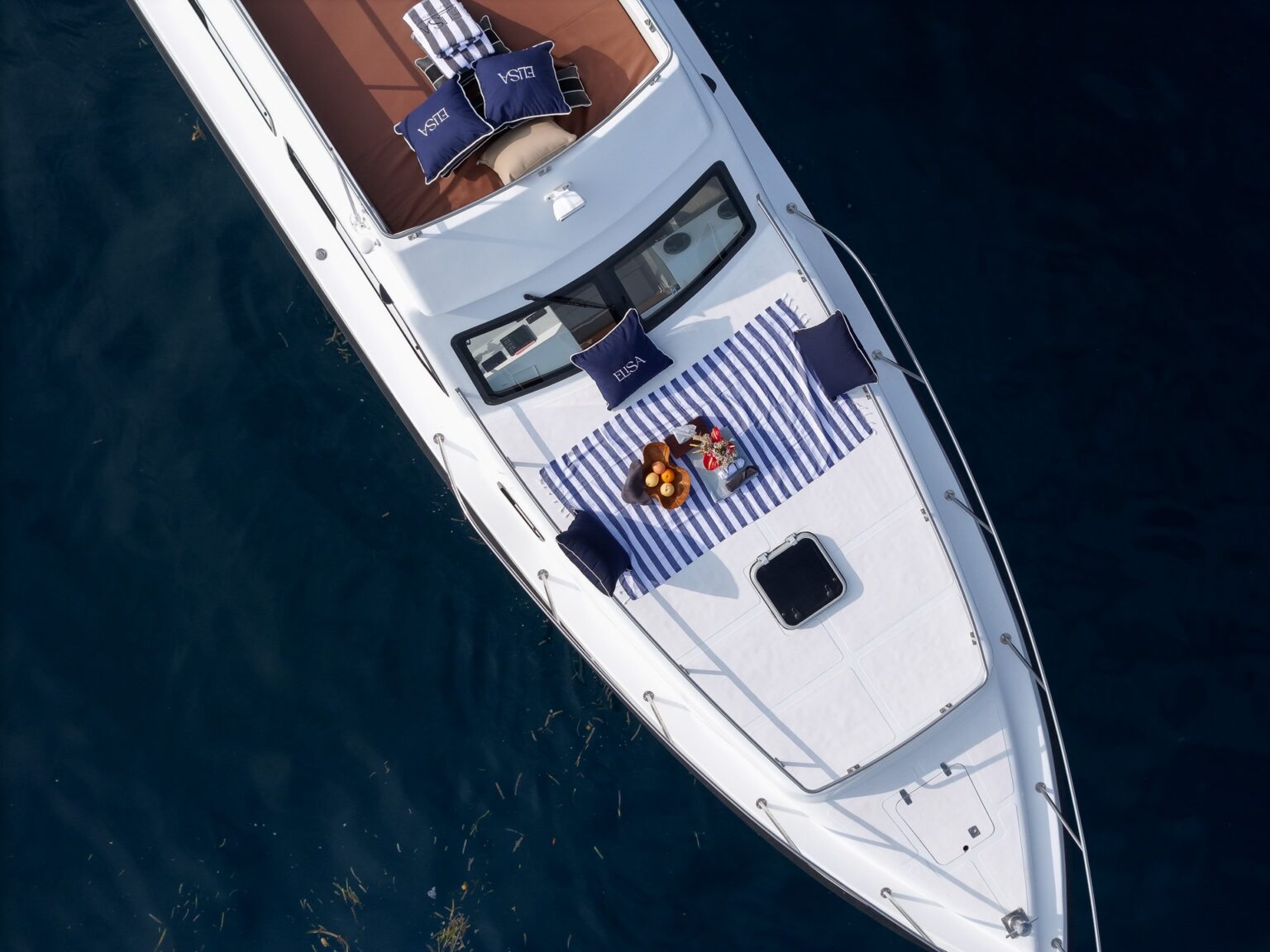 Overhead drone view of the Elisa speedboat bow deck with striped cushions
