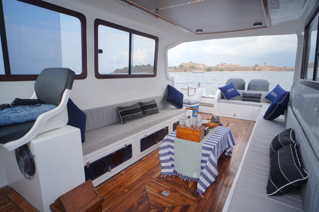 Elisa speedboat shaded lounge seating with striped cushions and an ocean view