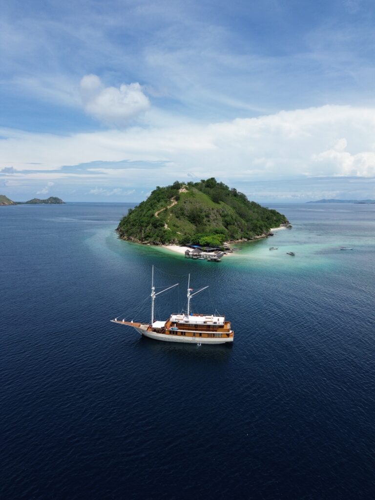 Boat anchored near a small green island close to Kelor Island