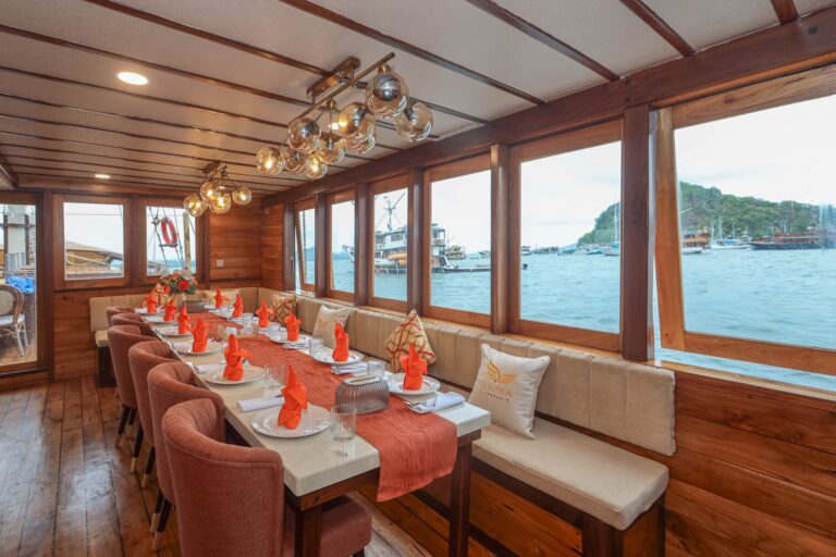 Elrora indoor dining room with orange napkins and ocean view windows