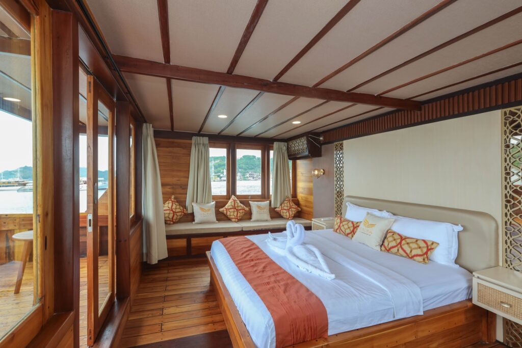 Elrora owners suite bed with swan towel art and a window seating nook